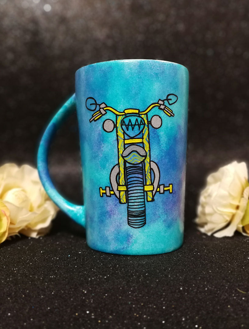 A Dark Sky Hand painted mug with a motorcycle front painted in black with patterns of yellow and greys