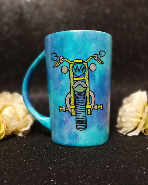 A Dark Sky Hand painted mug with a motorcycle front painted in black with patterns of yellow and greys