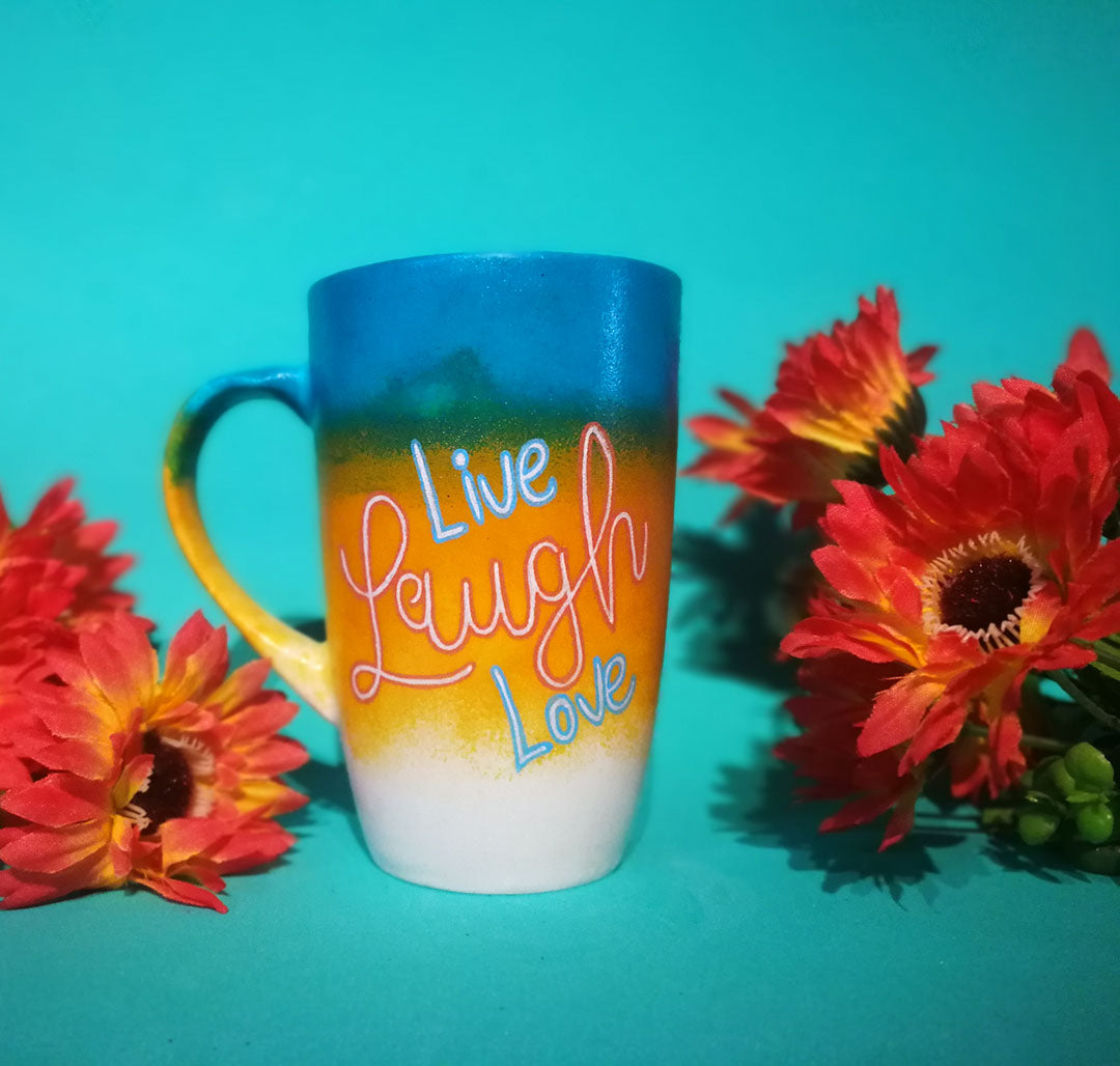 A gradient Hand Painted mug (from the top Blue, Bej and white) with the words Live Laugh Love