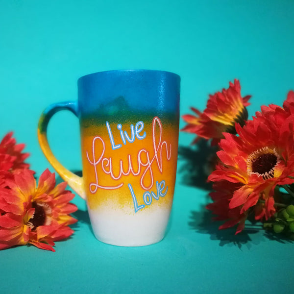 A gradient Hand Painted mug (from the top Blue, Bej and white) with the words Live Laugh Love