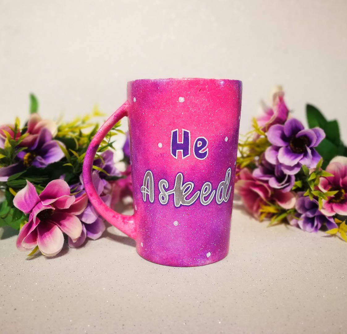 A hand-painted pink galaxy mug with the words "He asked" and white dots scattered all over