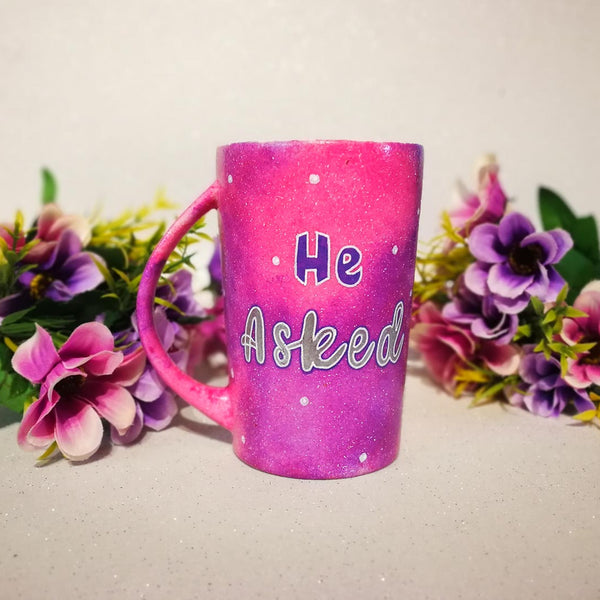 A hand-painted pink galaxy mug with the words "He asked" and white dots scattered all over