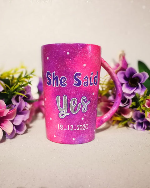 A hand-painted pink galaxy mug with the words "she said yes" and under it the date "18-12-2020" with white dots scattered all over