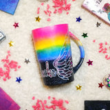 A gradient hand painted mug(rainbow colors in the top half and black galaxy in the bottom