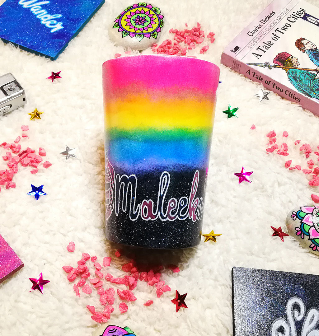 A gradient hand painted mug(rainbow colors in the top half and black galaxy in the bottom" with the name "Maleeka"