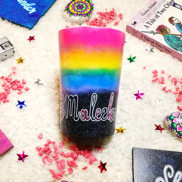 A gradient hand painted mug(rainbow colors in the top half and black galaxy in the bottom" with the name "Maleeka"