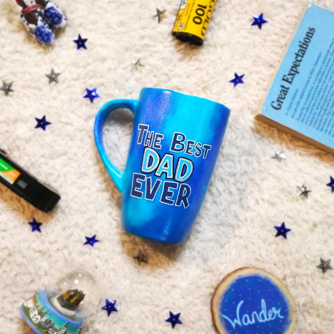 A blue hand painted mug with the words "The Best dad Ever"