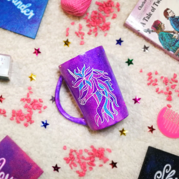 A purple galaxy hand painted mug with a zentangle unicorn design on it