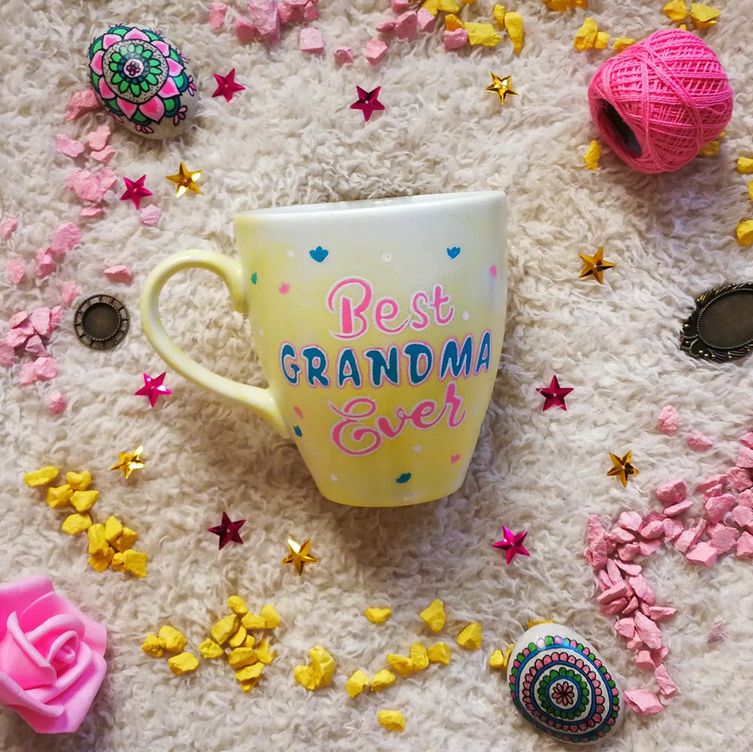 A Pastel yellow hand painted mug with the words "Best Grandma Ever"