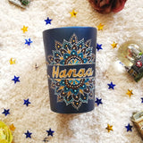 A Shimmery blue hand painted mug with a mandala split into 2 with a space in between that has the name 