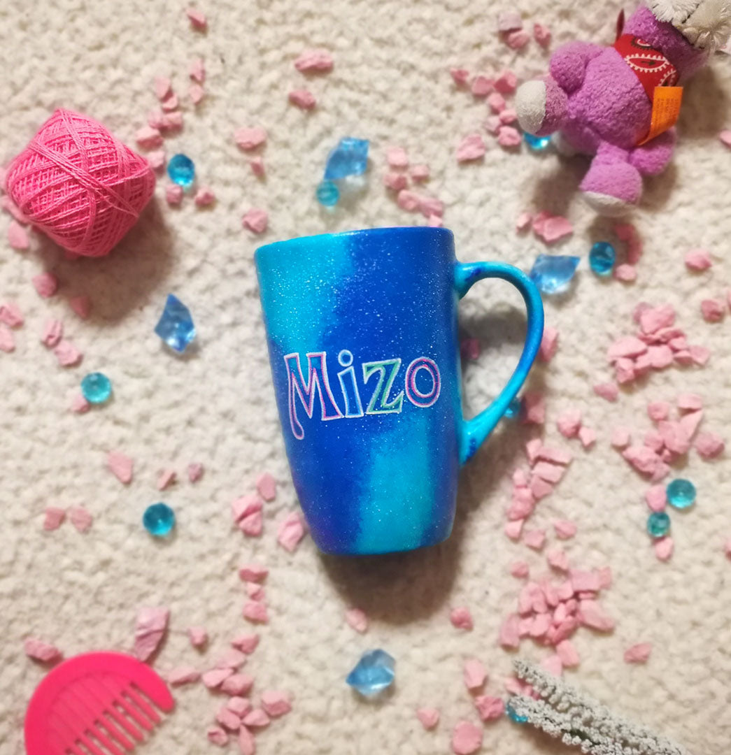 A blue galaxy hand painted mug with the name "Mizo"