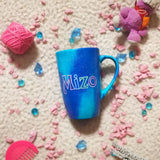 A blue galaxy hand painted mug with the name 