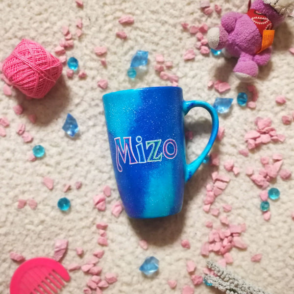 A blue galaxy hand painted mug with the name "Mizo"