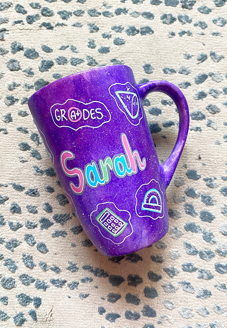 A Purple Galaxy Hand painted mug with the name "Sarah" and math icons scattered all over 