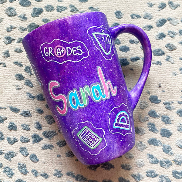 A Purple Galaxy Hand painted mug with the name "Sarah" and math icons scattered all over 