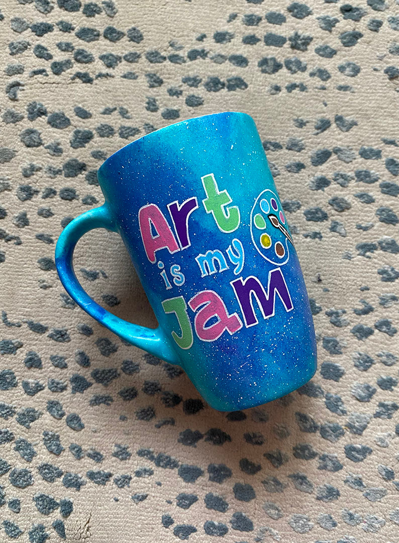 A Blue Galaxy Hand painted mug with the words "Art is my Jam" and a color palette drawn