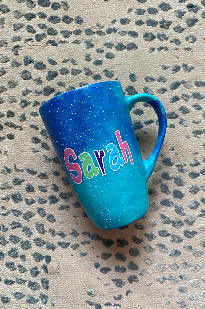 A Blue Galaxy Hand painted mug with the name "Sarah" 