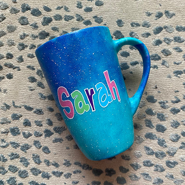 A Blue Galaxy Hand painted mug with the name "Sarah" 