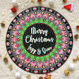 A Large 50cm in diameter mdf wooden plate, painted in black with a mandala drawn in white colored in green red and gold. and in the center the words 