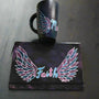 A black galaxy hand painted mug and notebook with a wings drawn on it and in between the mug has the name malak and the notebook has the word Faith