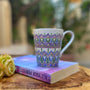 a white mug with patterns in lilac baby blue and pastel green outlined with silver relief and dot art of baby pink ultramarine blue, pastel green, lilac and white