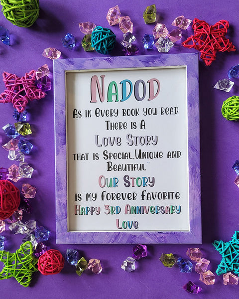 A Lilac Hand painted wooden frame with the following words written inside "Nadod, As in Every book you read there is a Love story that is special unique and beautiful, Our story is my forever favorite, happy 3rd anniversary"