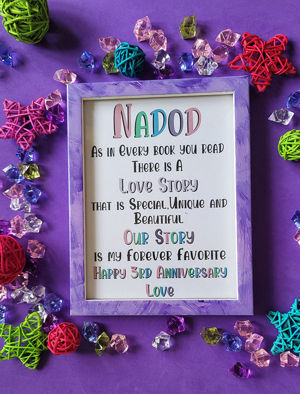 A Lilac Hand painted wooden frame with the following words written inside "Nadod, As in Every book you read there is a Love story that is special unique and beautiful, Our story is my forever favorite, happy 3rd anniversary"