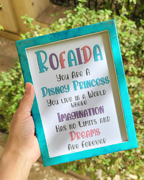 a mint hand painted frame with the following words written inside "Rofaida, you are a Disney Princess, You live in a world where Imagination has no limits and Dreams are forever"