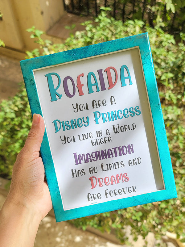 a mint hand painted frame with the following words written inside "Rofaida, you are a Disney Princess, You live in a world where Imagination has no limits and Dreams are forever"