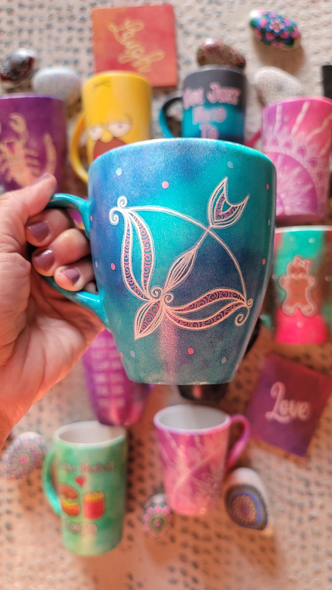 a hand-painted blue mug with a Sagittarius sign and blue and pink polka all around