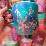 a hand-painted blue mug with a Sagittarius sign and blue and pink polka all around