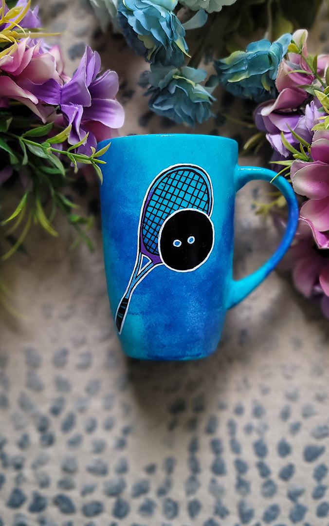 A Blue Hand painted mug with a drawing of a squash racket