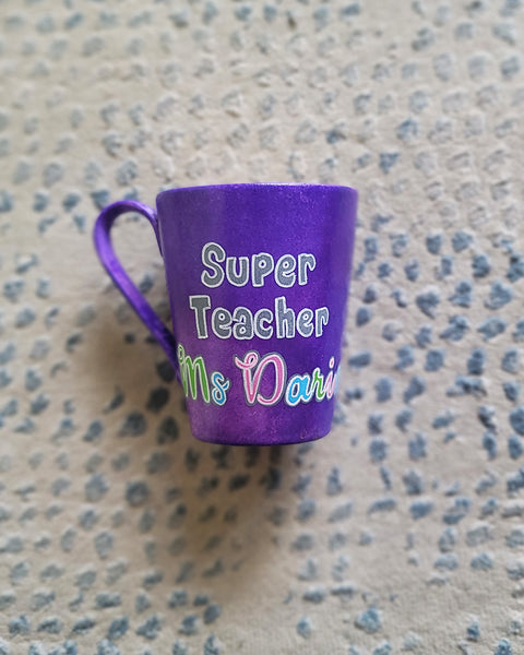 A Purple hand painted mug with the words "Super Teacher Ms.Darine"