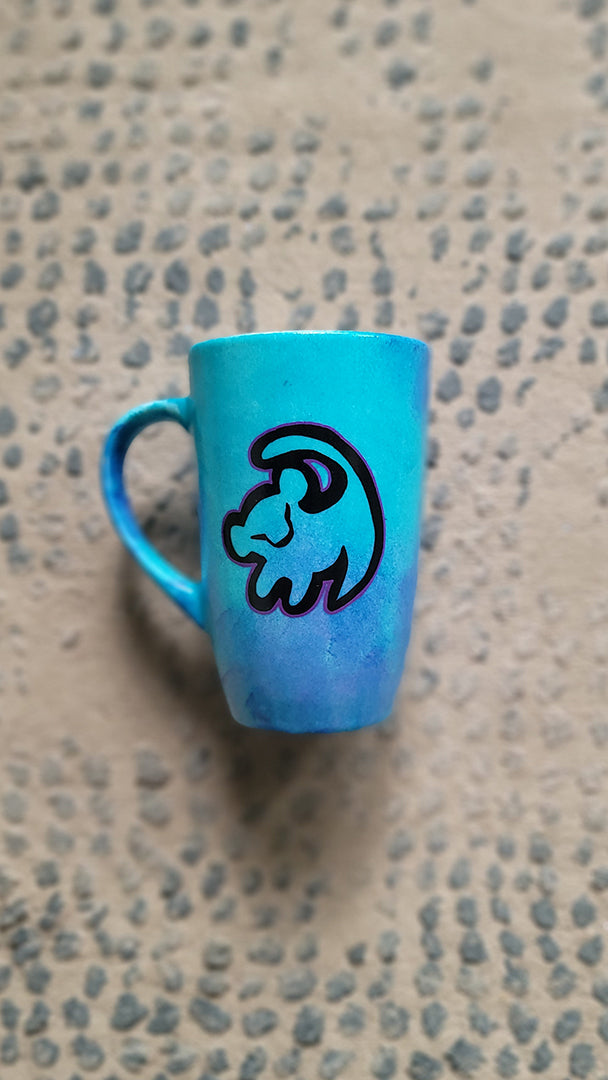 A Blue Hand painted mug with the an outline of baby lion in black