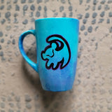 A Blue Hand painted mug with the an outline of baby lion in black