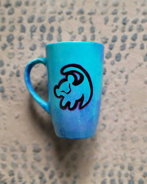 A Blue Hand painted mug with the an outline of baby lion in black