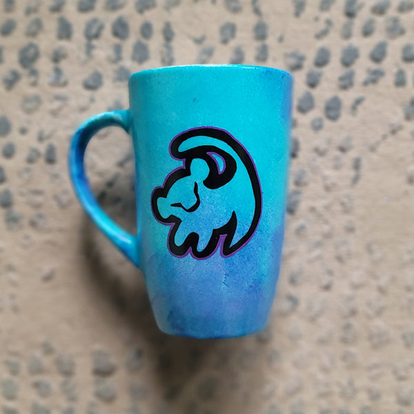 A Blue Hand painted mug with the an outline of baby lion in black