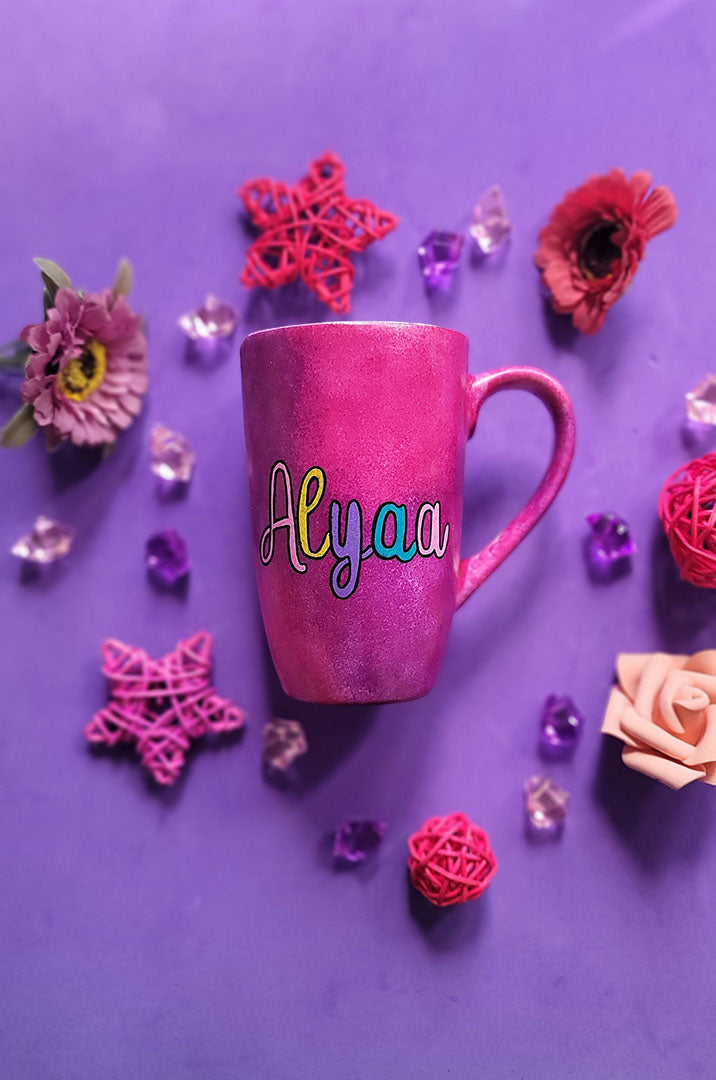 An indian pink hand painted mug with the name Alyaa