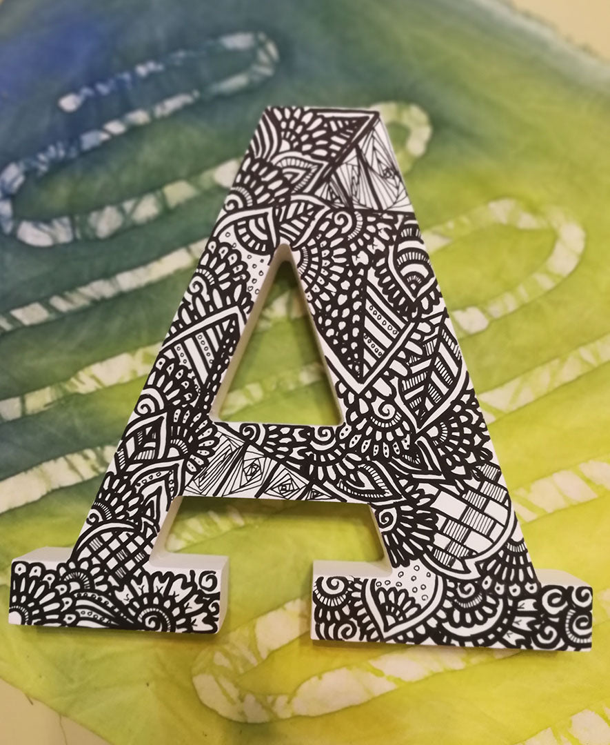 A White letter A with doodles drawn in bold black