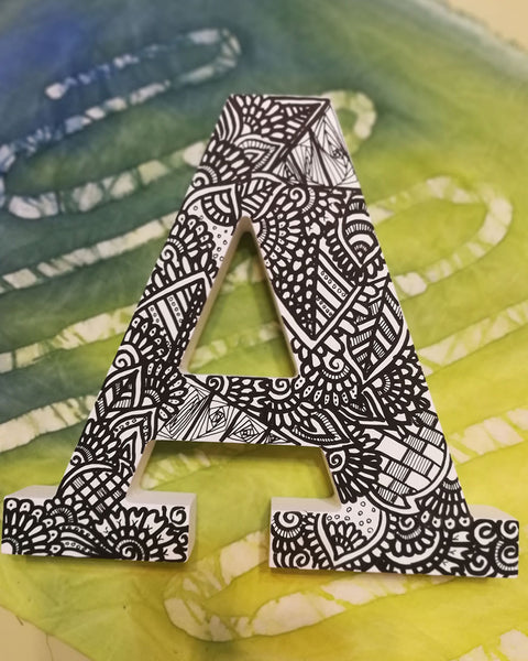 A White letter A with doodles drawn in bold black