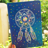 a Blue hand painted notebook with a dreamcatcher drawn in white