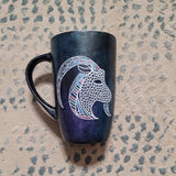 A Hand-painted dark galaxy mug with Capricorn sign in white and colored with patterns of pink blues and greens