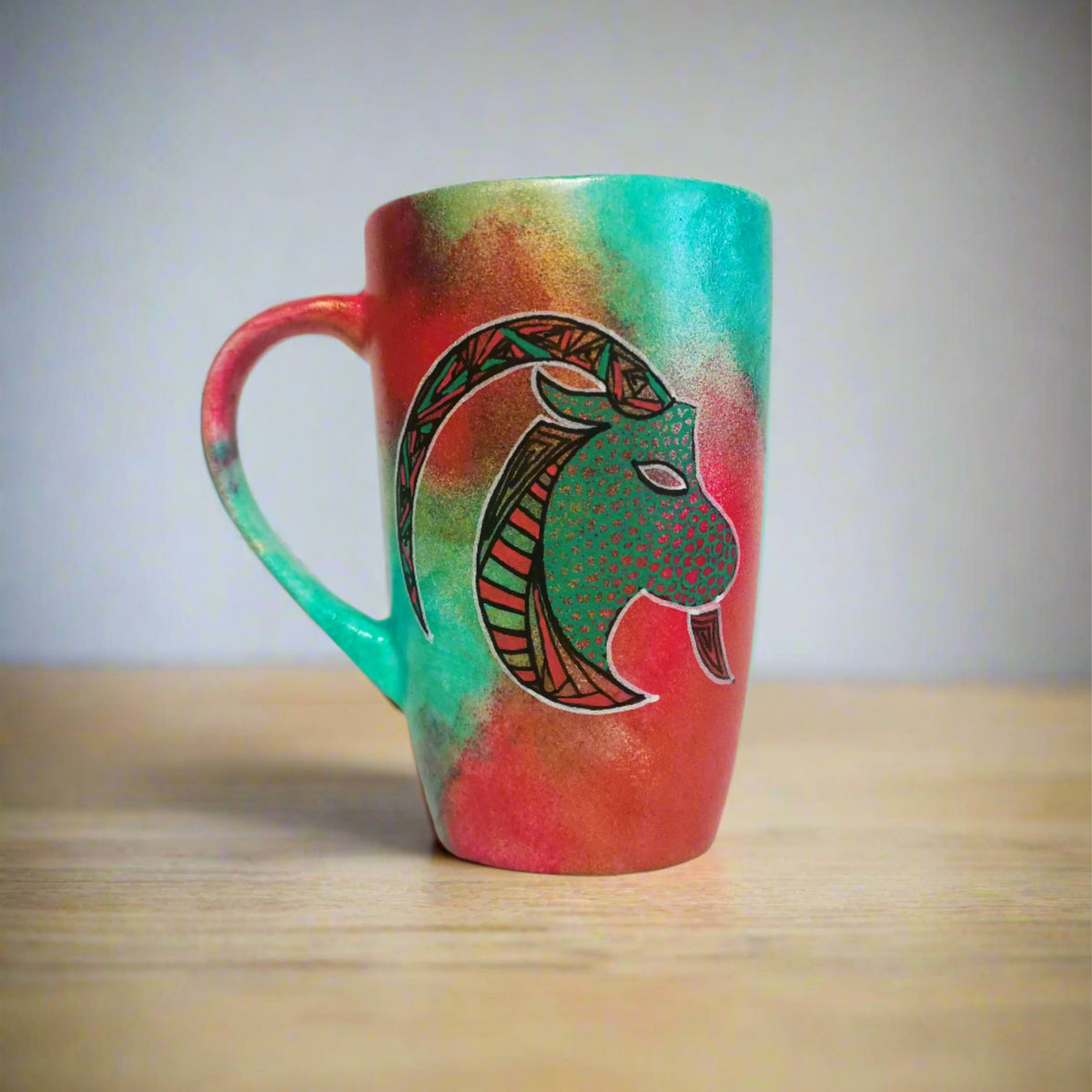 A Hand-painted Christmas color mug with Capricorn sign in black and colored in with green and red