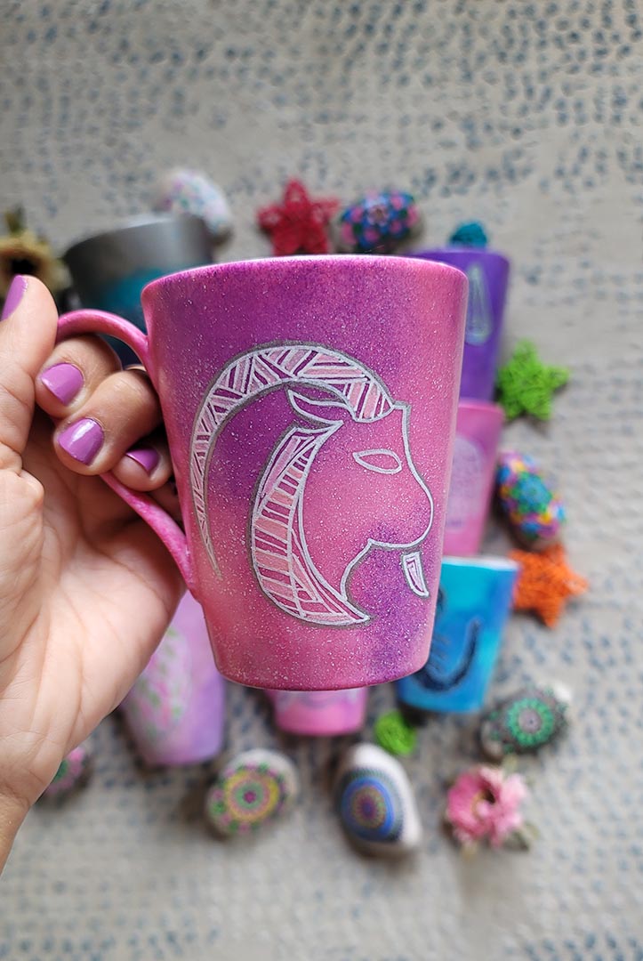 A Hand-painted pink galaxy mug with Capricorn sign in white and patterns in white and pinks