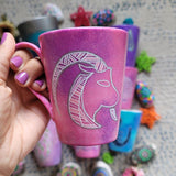 A Hand-painted pink galaxy mug with Capricorn sign in white and patterns in white and pinks