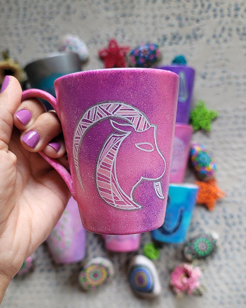 A Hand-painted pink galaxy mug with Capricorn sign in white and patterns in white and pinks