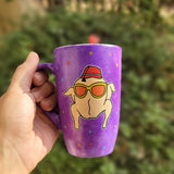 A Purple Hand painted mug with a turkey drawn on it wearing  sun glasses and tarboosh, with red yellow and blue dots scattered all over