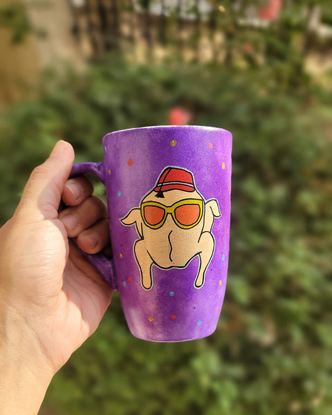 A Purple Hand painted mug with a turkey drawn on it wearing  sun glasses and tarboosh, with red yellow and blue dots scattered all over