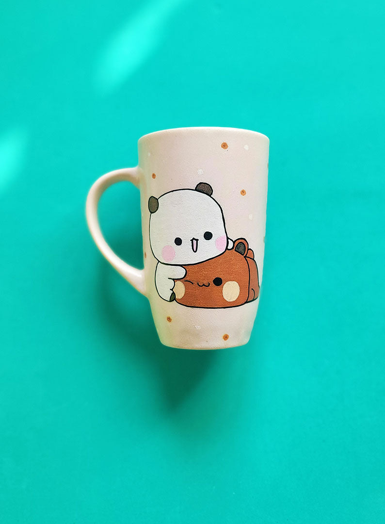 A Pale Pink Hand painted mug with the design of 2 cute bears cuddling (one bear is white and the other is brown)