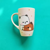 A Pale Pink Hand painted mug with the design of 2 cute bears cuddling (one bear is white and the other is brown)